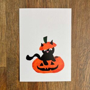 Grijze kaart met kat in pompoen