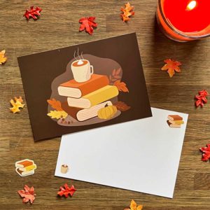 Bruine postkaart met illustraties van boeken, herfstbladeren, warme chocolade melk en witte envelop van Pinkstore